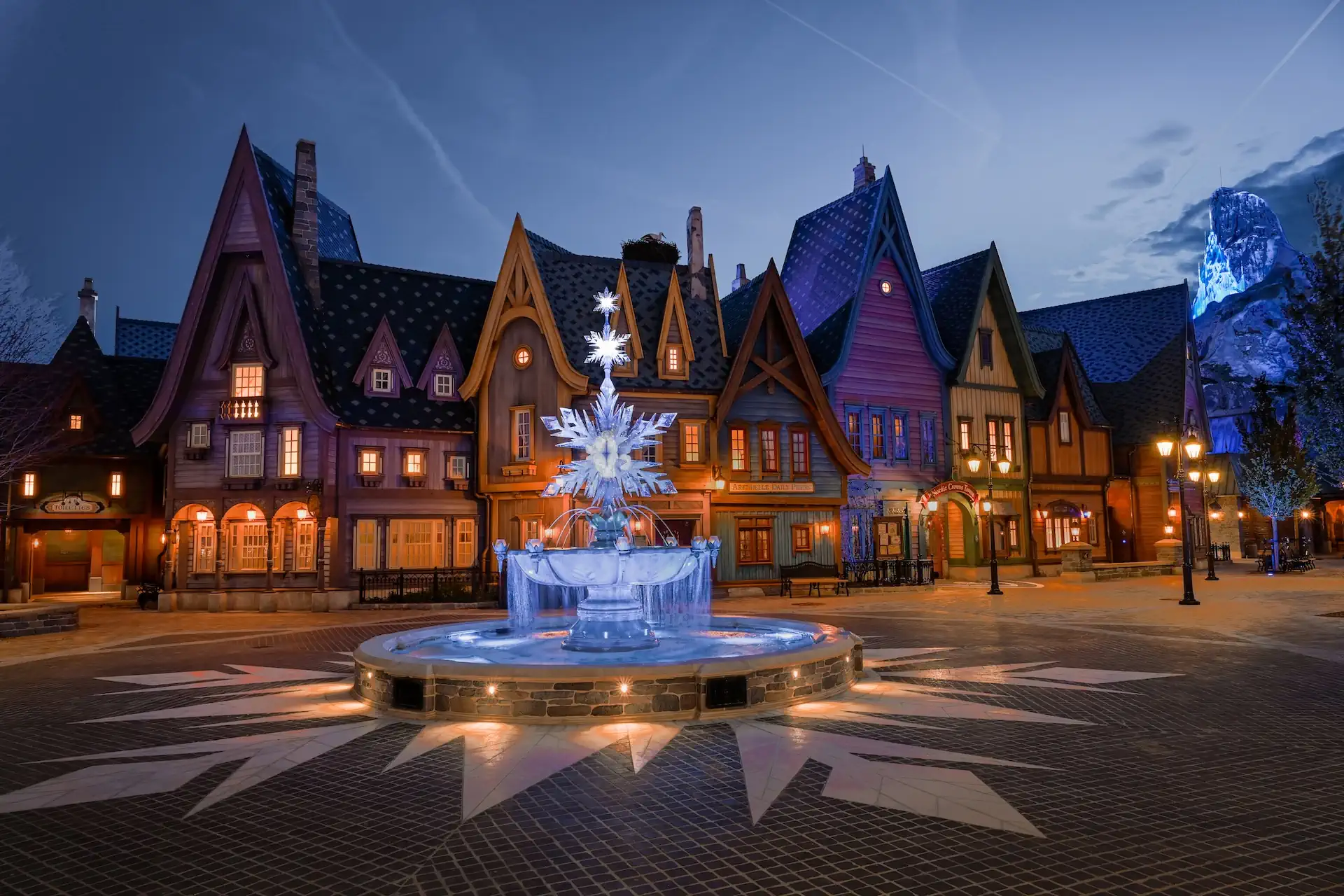 Praça do World of Frozen na Disneyland Paris com fonte iluminada e edifícios inspirados em Arendelle