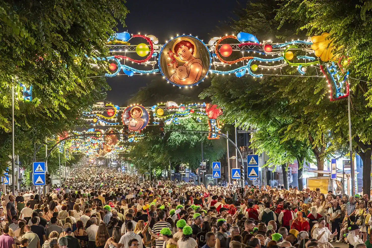 Avenida da Liberdade em Braga iluminada durante as festas de São João, com multidão e decorações populares