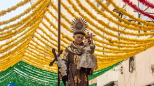 Imagem de Santo António durante a procissão numa rua decorada de Lisboa