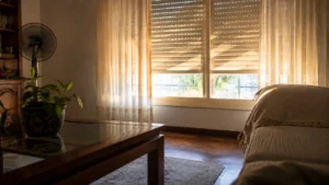 Sala com estores parcialmente fechados e ventoinha durante uma tarde quente de verão.